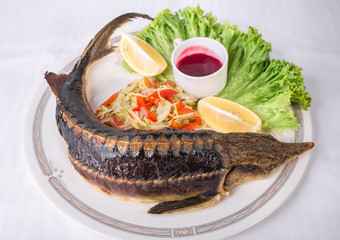 Baked sturgeon with vegetables.