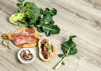 bruschetta with olive paste, parma ham, broccoli and anchovy