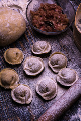 Raw meat dumplings. Ingredients for making dumplings: dough, minced meat, eggs on the wooden background