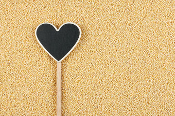 Pointer in the form of heart lies on millet grains