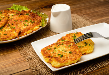 Potato pancakes on brown wooden table.