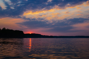 Naklejka premium sunset and reflection with dramatic sky (toned image)