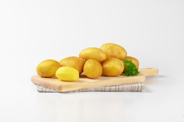 raw potatoes on cutting board