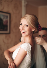 Fototapeta premium Gorgeous blonde bride in robe posing and preparing for the wedding ceremony face in a room