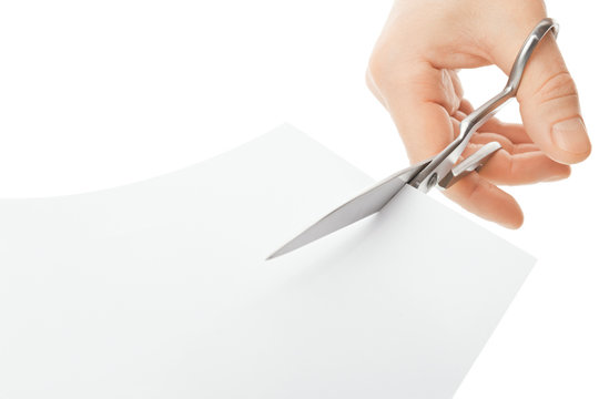 Hand With Scissors Cutting A White Sheet Of Paper