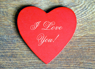 Valentines Day decorative red heart on wooden background.