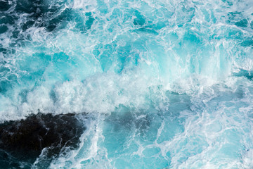 Fototapeta premium fale oceanu rozbijające się o skały z białą pianą