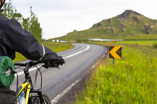 Biker rides on road at summer day in Iceland. Travel and sport picture