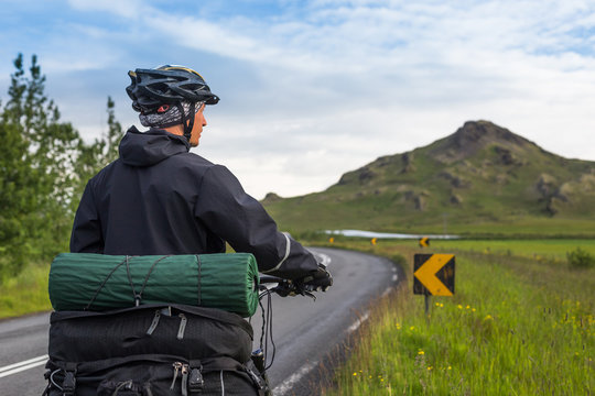 Biker rides on road at summer day in Iceland. Travel and sport picture