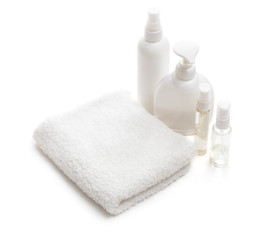 Obraz na płótnie Canvas White towel and bottles with cosmetics