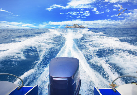 rear view of speed boat running over blue ocean