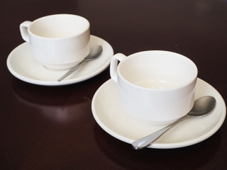 Couple of white coffee cup on the brown table