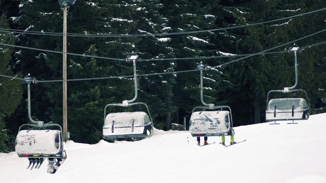 Skiers On Chairlift WIth Their Legs Dangling