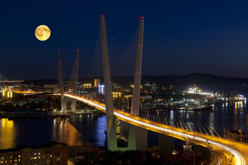 Obraz premium Panorama of night Vladivostok in the full moon. Golden bridge. Russia
