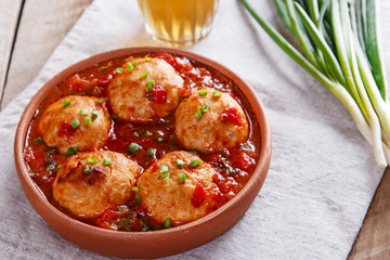 Chicken meatballs with tomato sauce in a clay bowl
