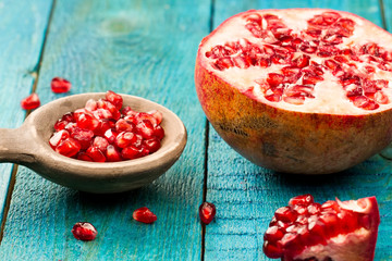Ripe pomegranate fruit on wooden vintage background. Healthy vegetarian food. Recipe, menu, mock up, cooking.