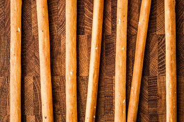Salted bread sticks lie on a chopping board