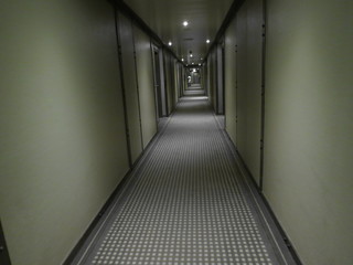 Empty green long corridor with medium light