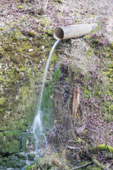 Wasser fällt aus der Zuleitung im Wald