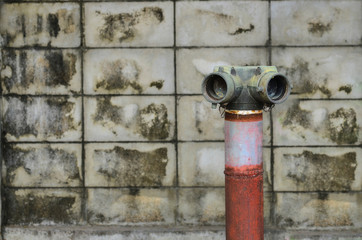 Fototapeta na wymiar red fire hydrant near a cement wall