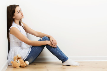 sad teen girl on floor with toy