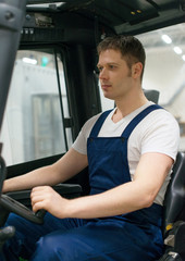 Handsome forklift operator working in the warehouse.