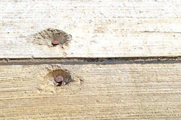 nails into the concrete wall