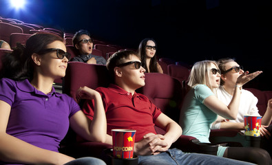 Obraz premium Young people sitting at the cinema, watching a film