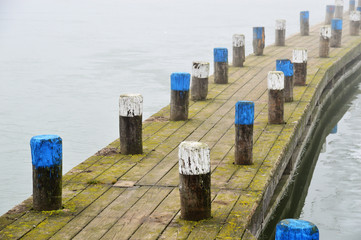 Holzsteg im Nebel im gefrorenen See