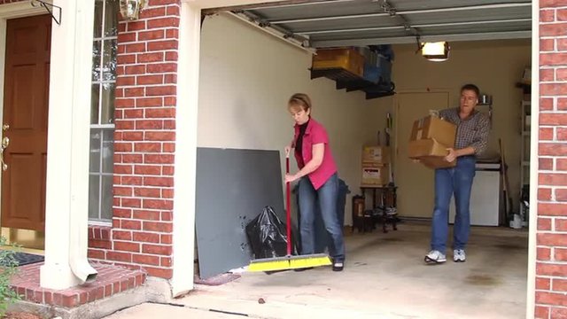  Mature Couple Working To Clean The Garage.