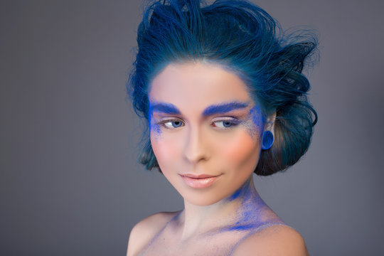 Beautiful woman with bright creative make up in blue