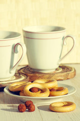 Obraz na płótnie Canvas Two cups for tea with fragrant bagels on a white wooden background