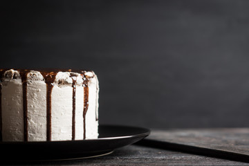 Creamy cake with chocolate glaze on the rustic background