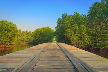 Wooden bridge in the countryside crossing the river at sunset. S