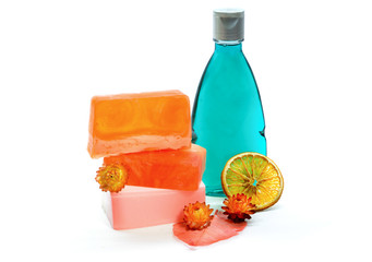 Handmade soap and blue colored shower gel bottle. Isolated on white background