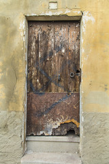 Old wooden door broken on a damaged wall