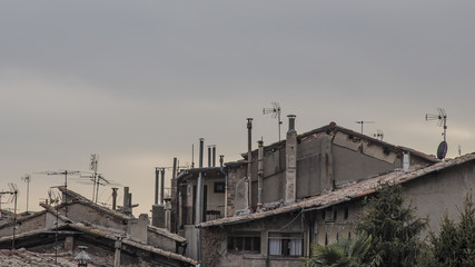 Roof cityscape with many old chimneys on a grey cloudscape