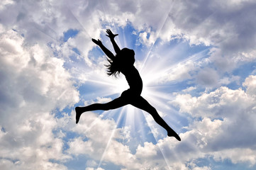 Silhouette of happy girl jumping