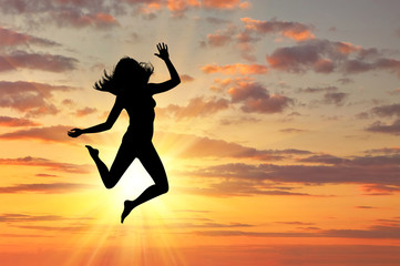 Fototapeta na wymiar Silhouette of happy woman jumping