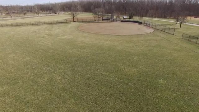 Flying over infield of baseball field during winter season.