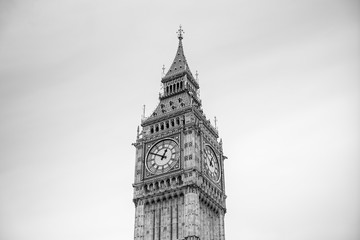 detailed close-up of Elizabeth Tower (Big Ben Clocktower) in front of gray cloudy sky, black and...
