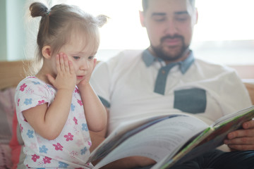 Emotional toddler girl reading a fairy tail