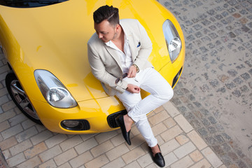 Stylish young man posing with sport car