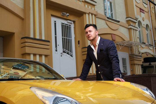 Stylish man posing with convertible sportcar