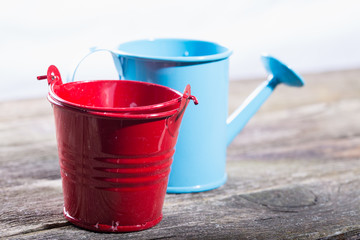 Garden bucket and watering can on old gray boards