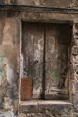 Wooden rusty door on an old rock building