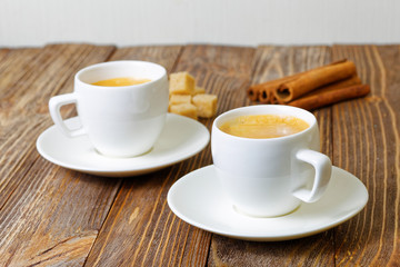 Two cup of hot esspresso, cinnamon and sugar cane