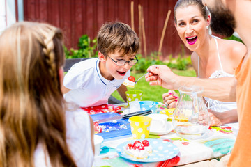 Familie im Garten bei Kaffee und Kuchen