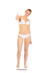 Fototapeta premium Happy woman standing on scales