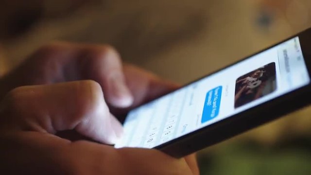 woman typing text on a smartphone, close-up